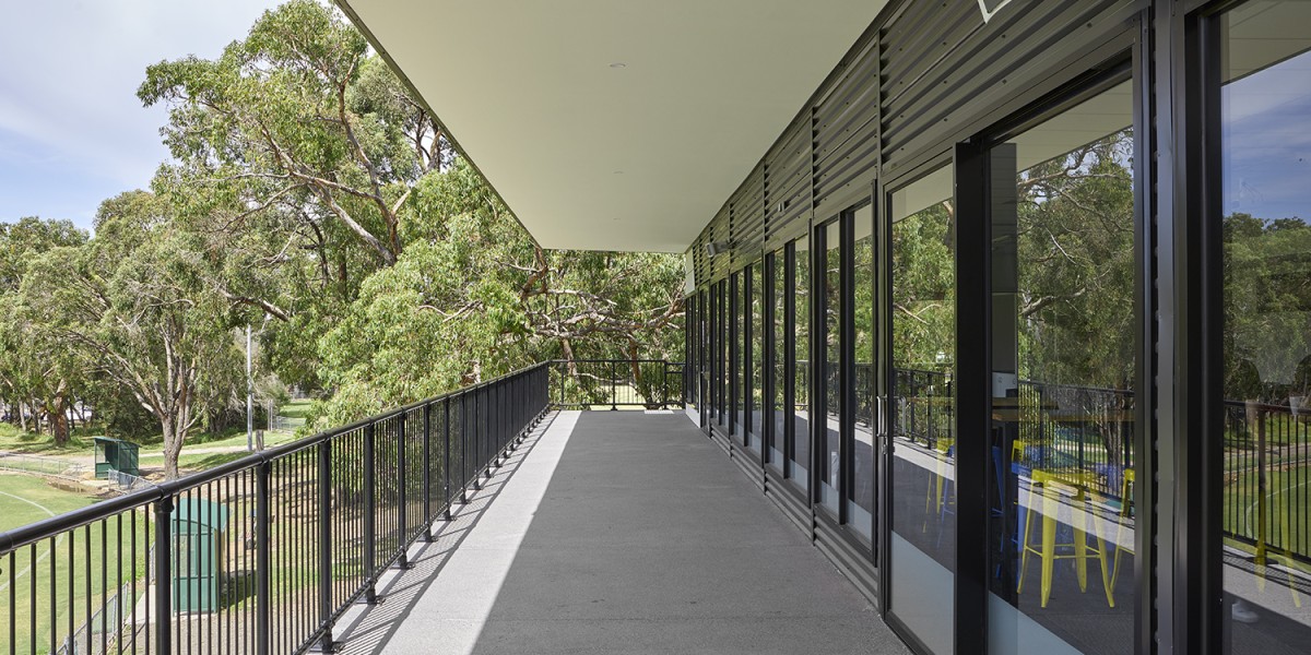 Building Exterior with Glass Doors and Balcony Facing Sports Grounds