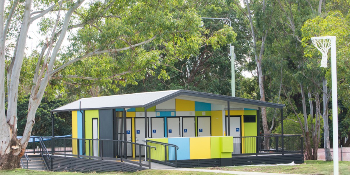 Brightly Coloured Modular Toilet Block on Lawn Beneath Trees