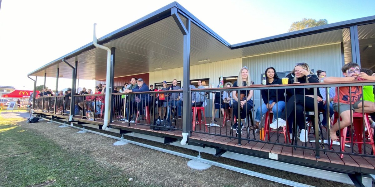 Exterior Sports Building with People Sitting on Deck Facing Sports Field