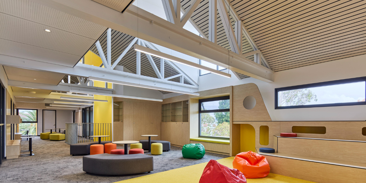 Bright, open learning space at Highgate Primary School featuring colourful furniture, exposed ceiling beams and natural light in a permanent modular building.