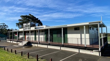 Exterior of Sports Facility Building in Bitumen and Lawn