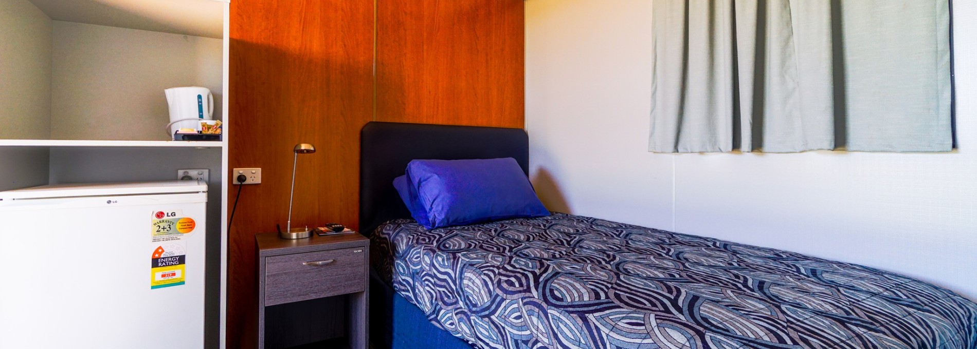 Interior of Residential Accommodation in Karratha with Bed and Mini Fridge