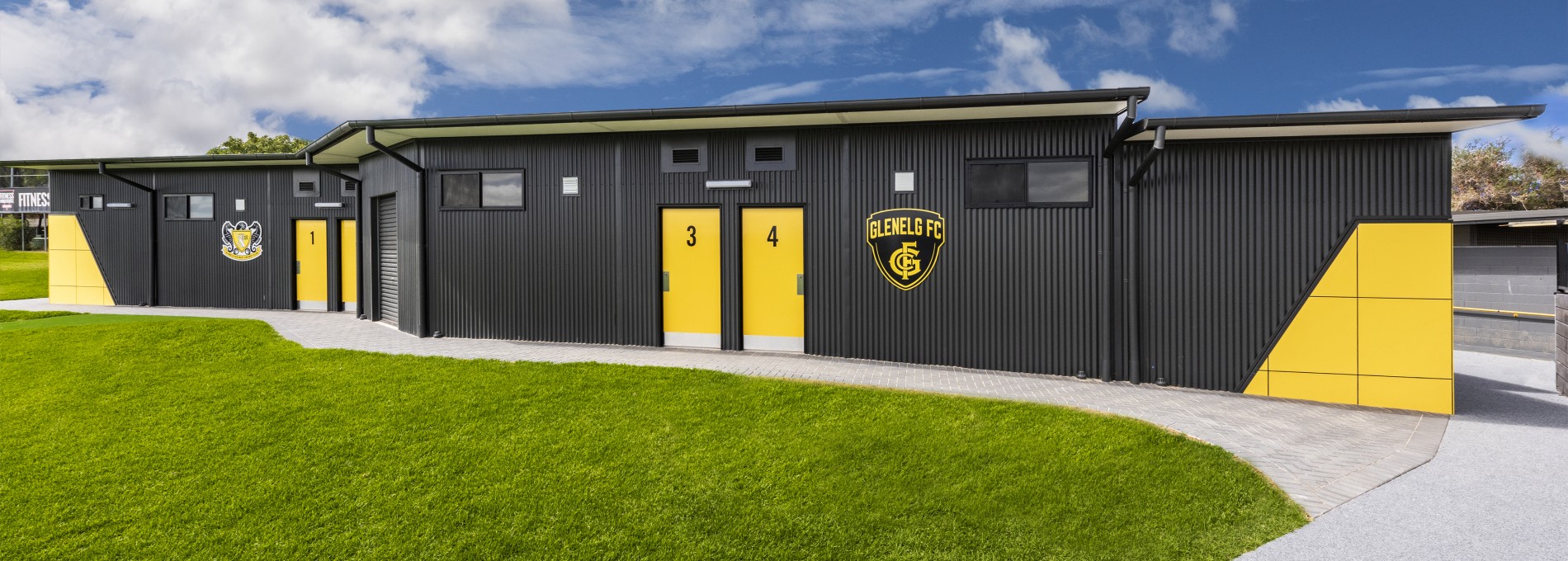 Modular Sports Building with Grey Steel Cladding and Yellow Panelling