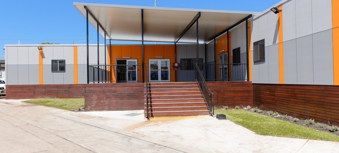 Exterior Modular Building with Grey and Orange Panelling, Covered Deck and Stairs