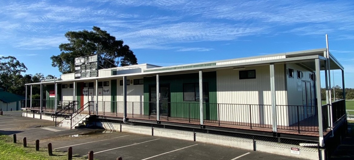 Exterior of Sports Facility Building in Bitumen and Lawn